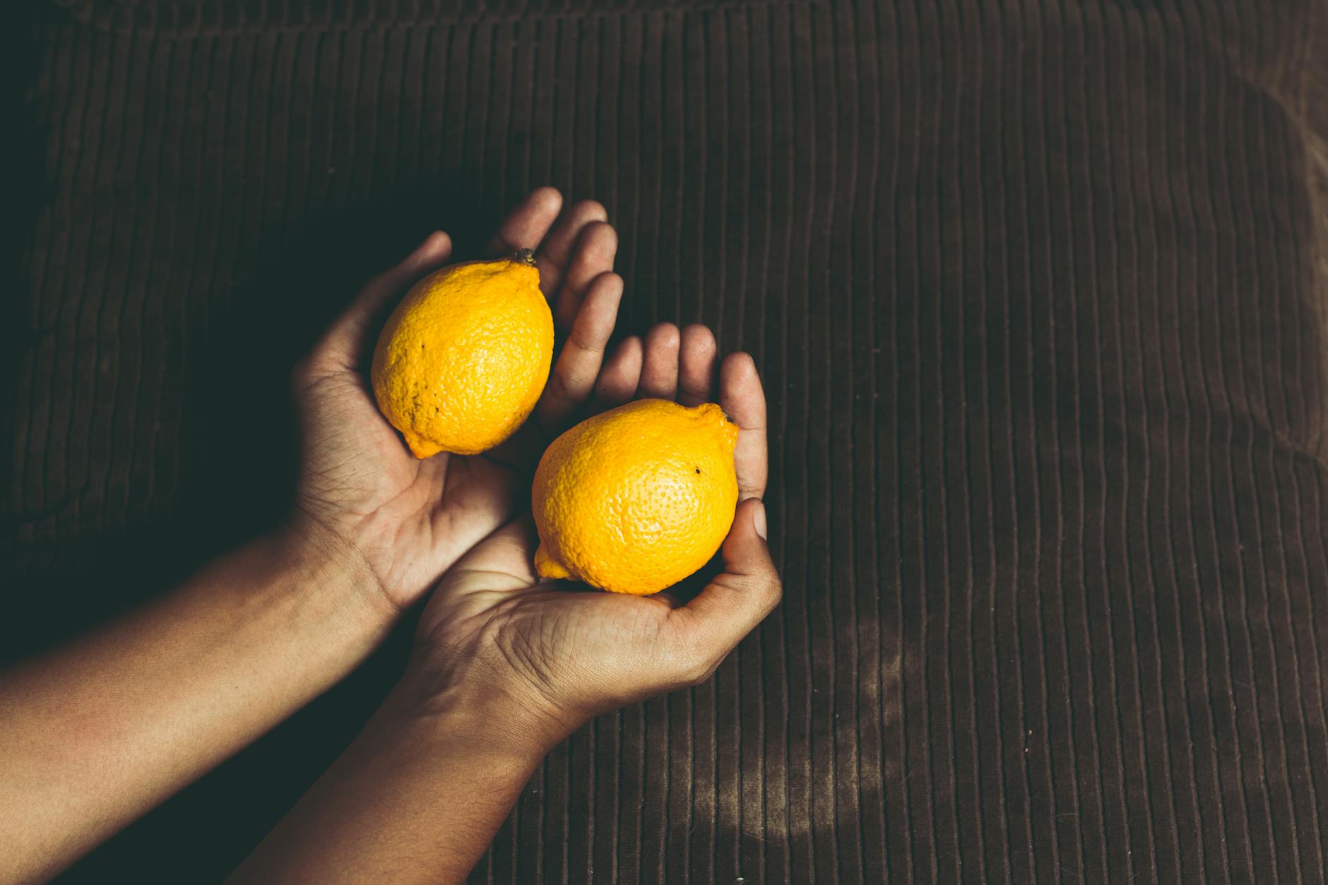 Close-up of fresh lemons held in hands, symbolizing the smooth, gentle sensation of lemon vibrators