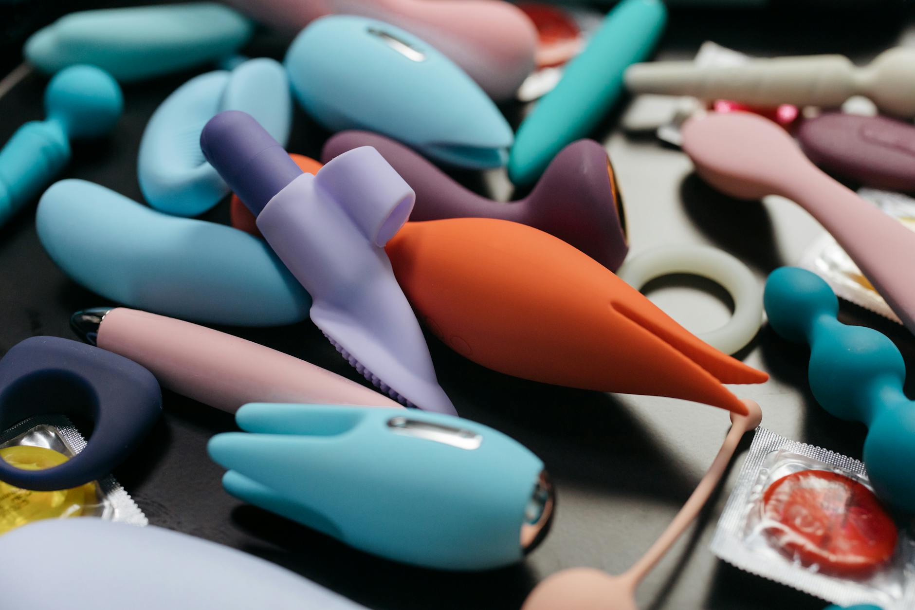 Array of vibrant clitoral vibrators including lemon and other shapes on a neutral background