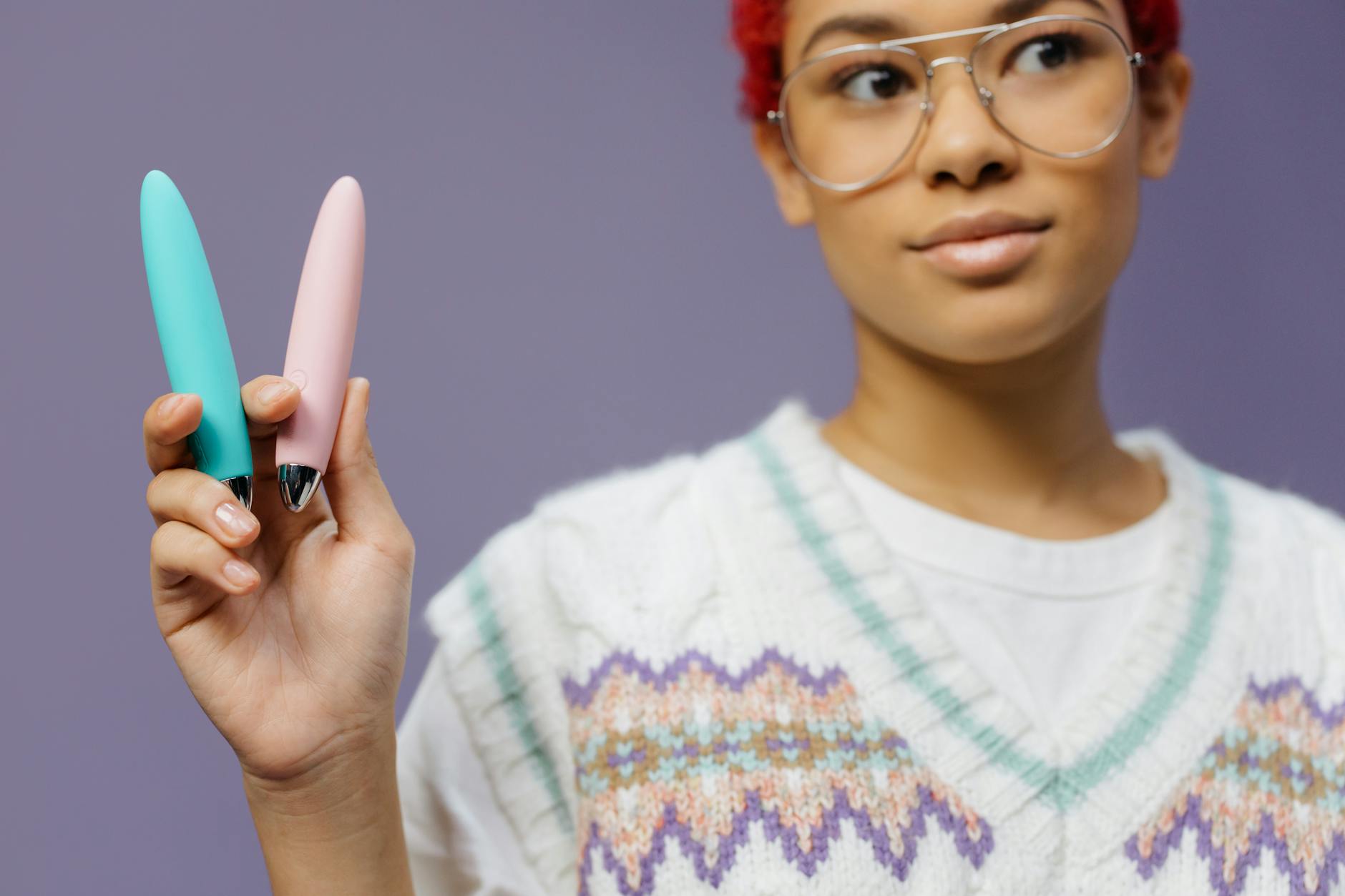 Woman holding colorful lemon vibrators against purple background, representing reclaimed pleasure and sensory recovery