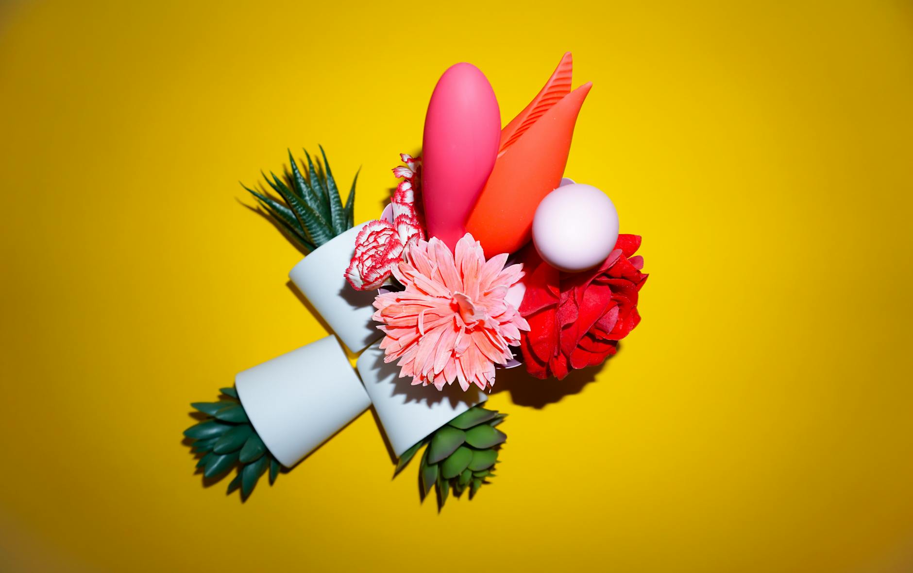 Woman holding colorful vibrators in contemplative pose